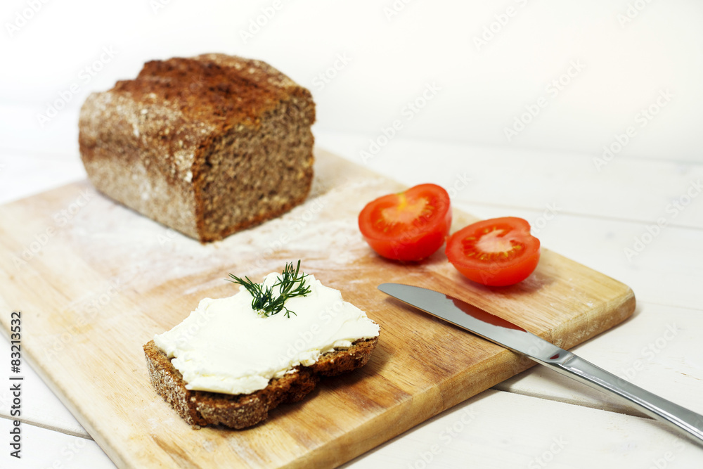 Bread lice with cream cheese and tomatoes on wood cutter Bread lice with cream cheese and tomatoes on wood cutter