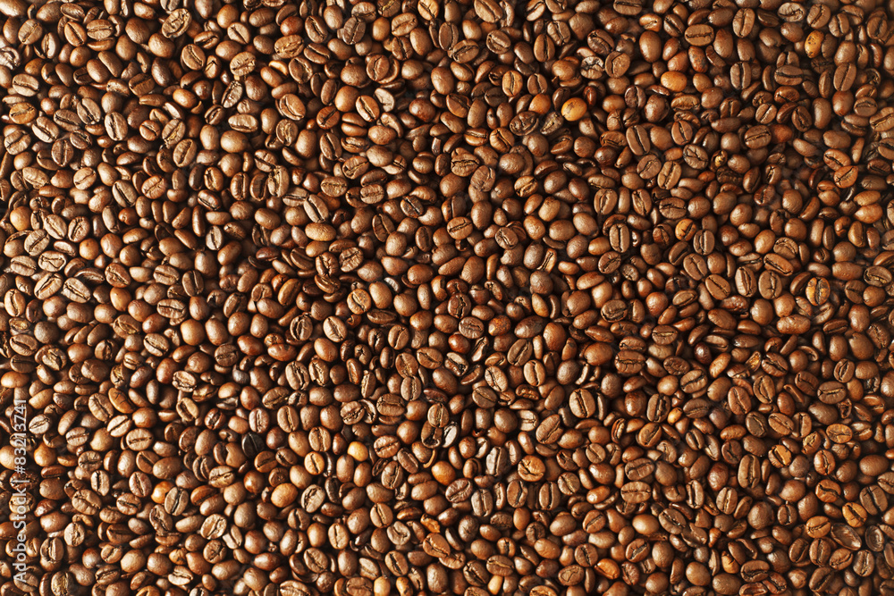 Top view of roasted coffee beans spread on stone table
