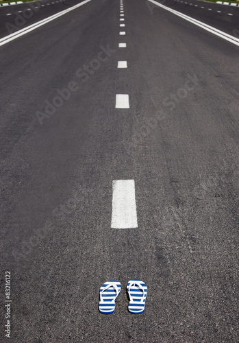 slippers with stipes lying on grey asphalt