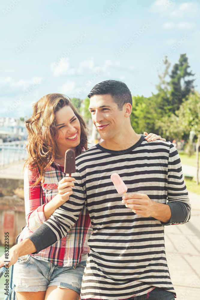 Happy couple outdoors eating ice cream