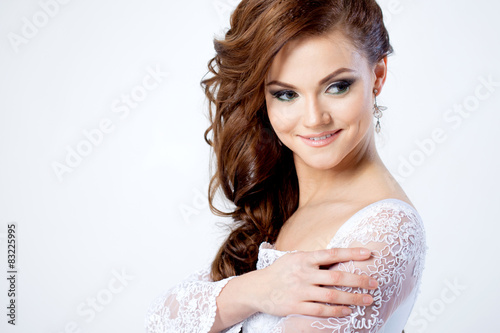 Portrait of happy bride in wedding dress, white background