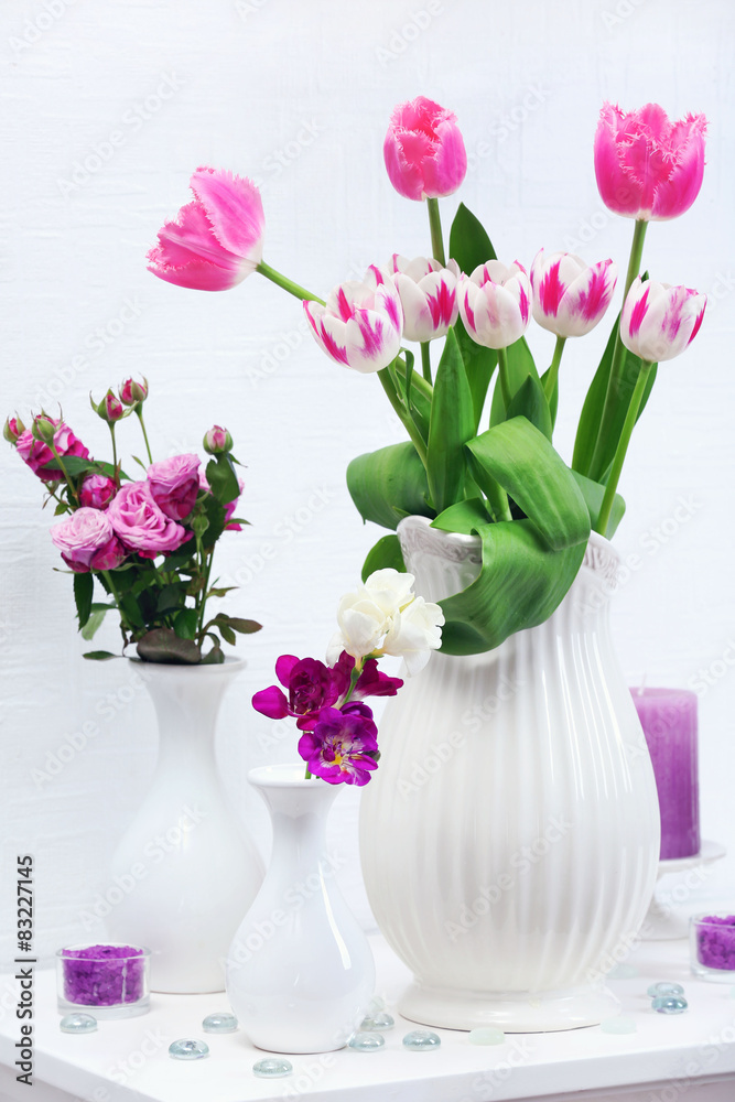 Fototapeta premium Beautiful composition with different flowers in vases on wall background