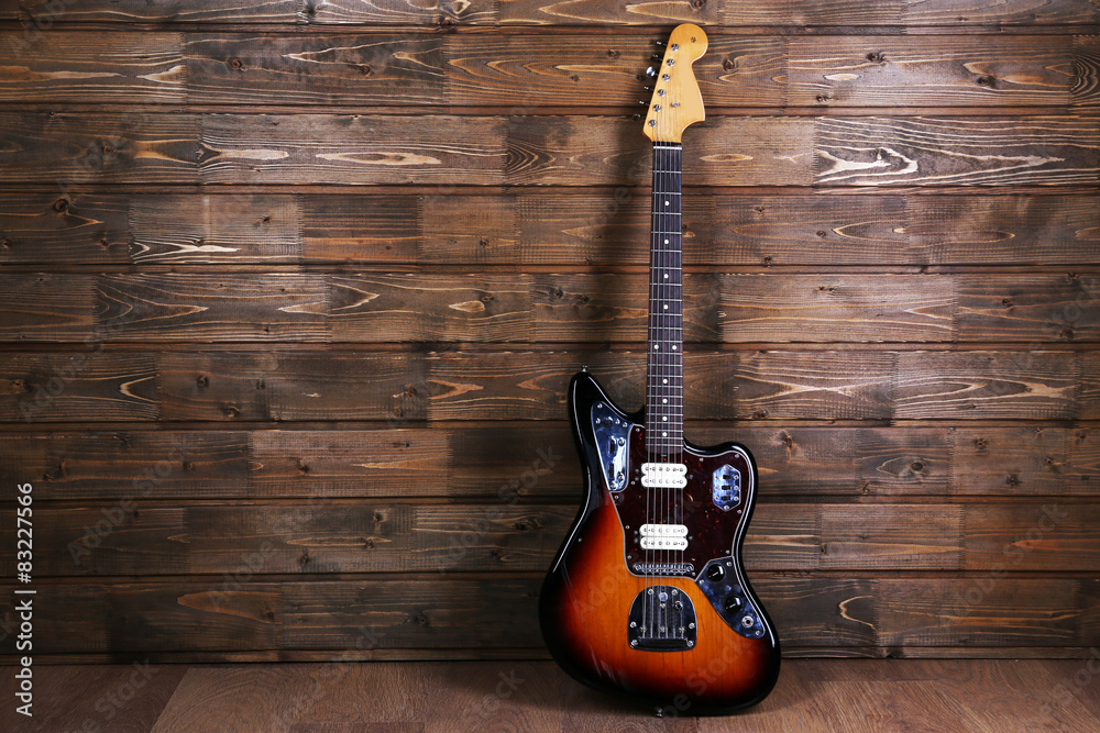 Naklejka premium Electric guitar on wooden background