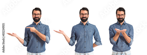 Young hipster man holding something over white background