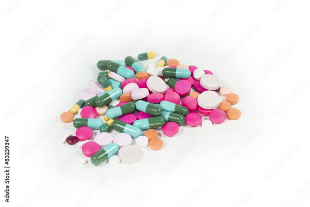 Stack of different pills on white background