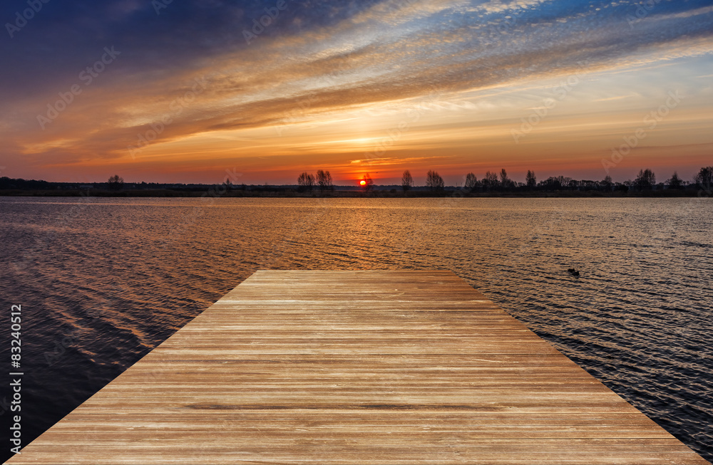 Wooden pier over a water at sunrise