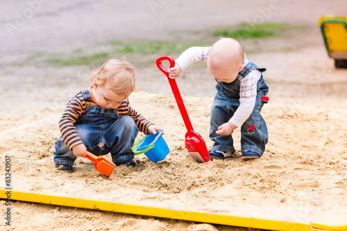 Foto Two baby boys playing with sand