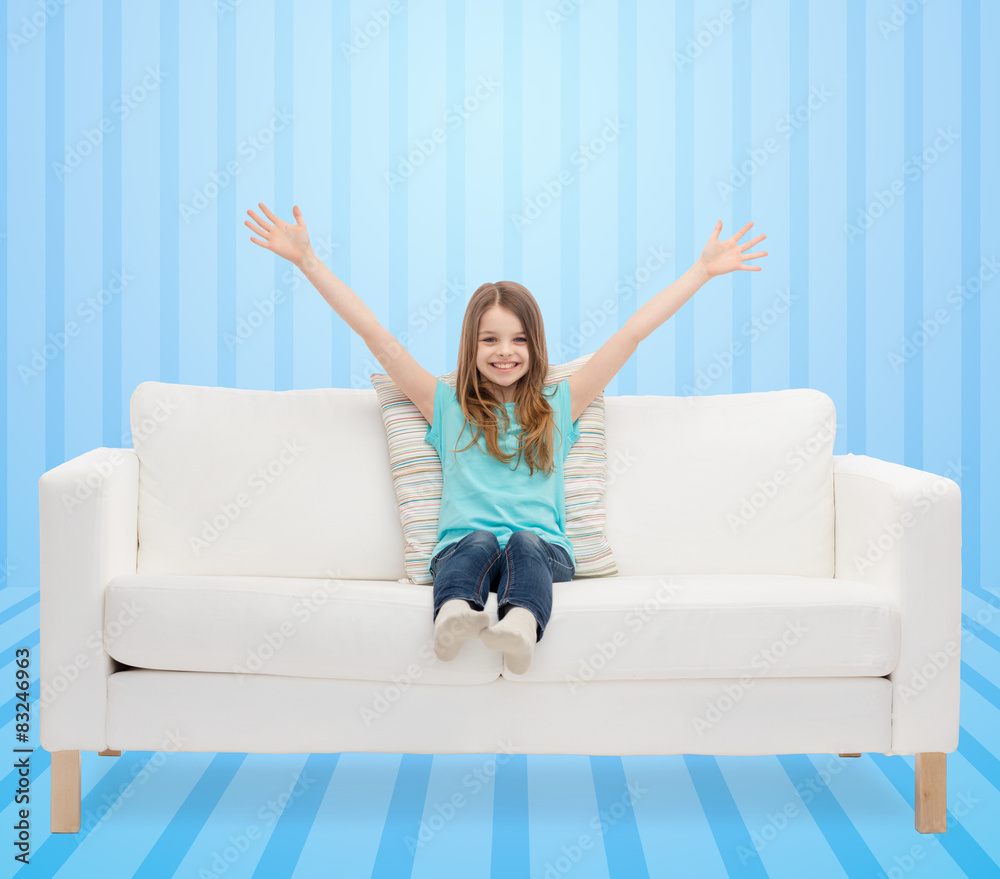 happy girl sitting on sofa with raised hands