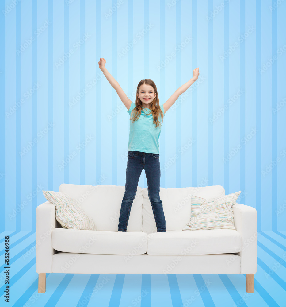 smiling little girl jumping on sofa smiling little girl jumping on sofa
