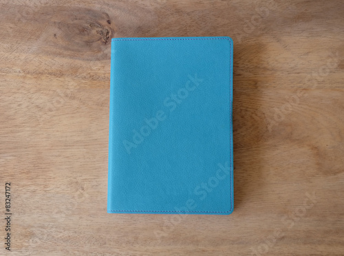 Sky blue leather notebook on wooden table, the personal organize