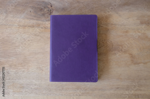 Purple leather notebook on wooden table, the personal organizer