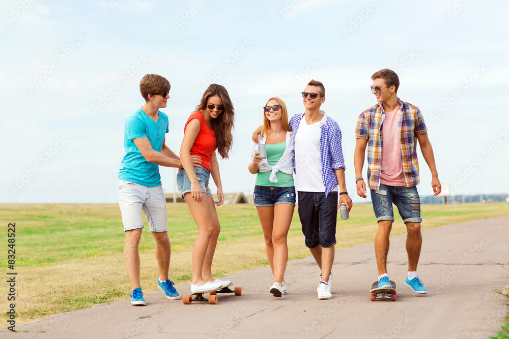Obraz premium group of smiling teenagers with skateboards