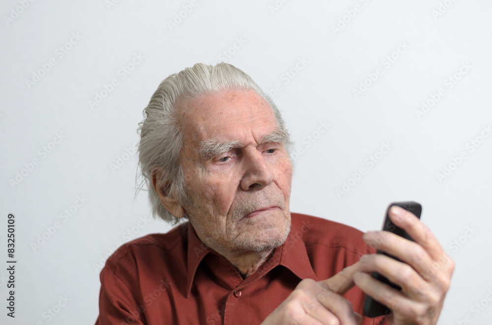 Älterer Mann schreibt SMS mit seinem Handy Älterer Mann schreibt SMS mit seinem Handy