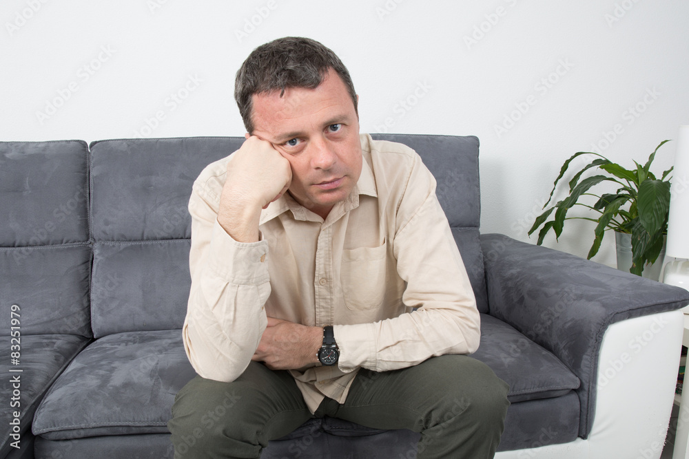 Portrait of a upset  man sitting on sofa in house