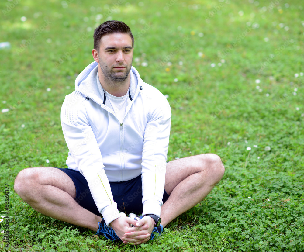 Fototapeta premium Handsome sportsman stretching outdoors