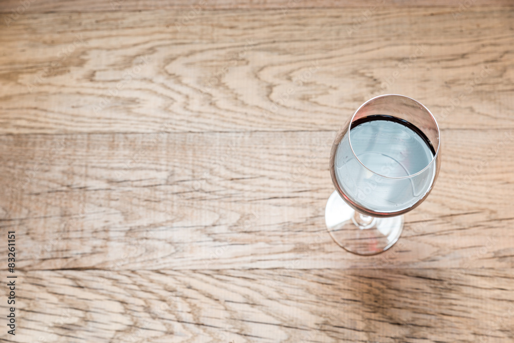 Fototapeta premium Glass with red wine on the wooden background