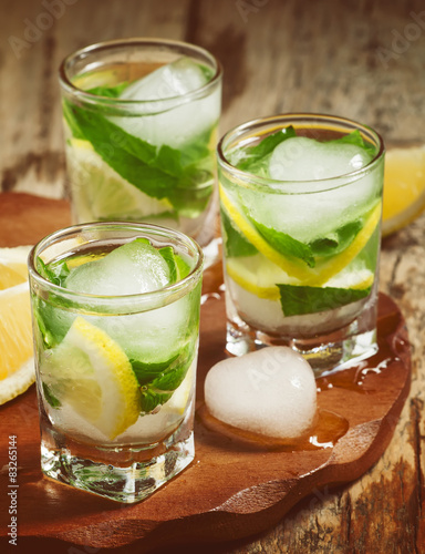 Glass of water with fresh lemon, ice and mint, selective focus
