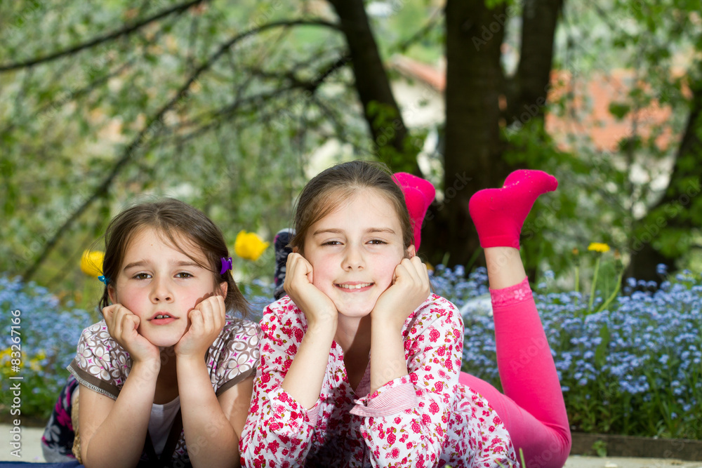 Two little sisters spending time together in spring day Two little sisters spending time together in spring day