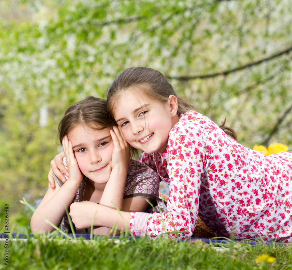 Two little sisters spending time together in spring day Two little sisters spending time together in spring day