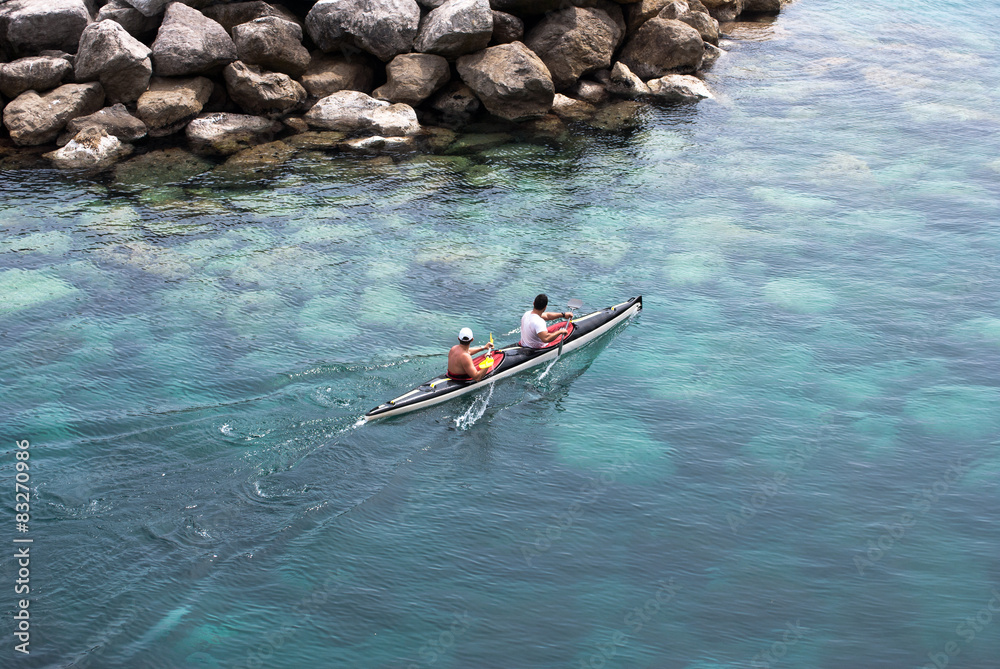 Fototapeta premium Two men padding in a canoe