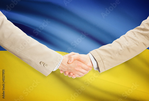 Businessmen handshake with flag on background - Ukraine