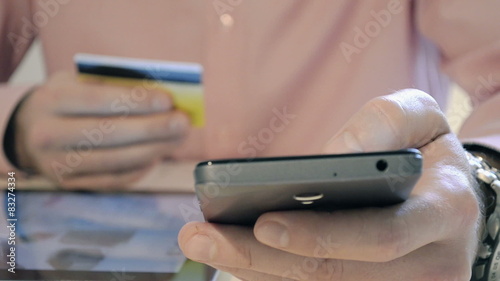 Man using credit card and smart-phone for online shopping