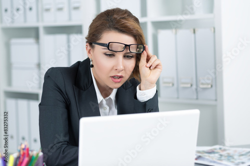 Young business woman looking intently at laptop