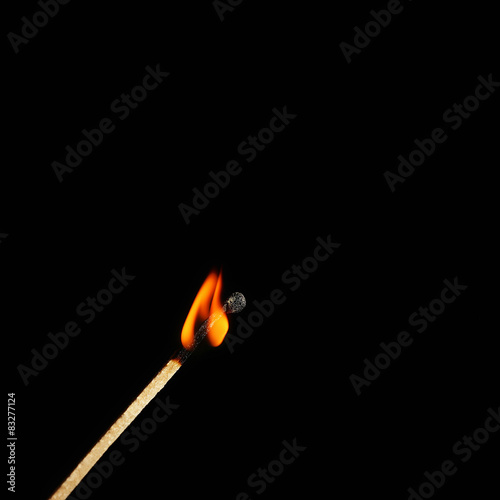 Burning match on black background