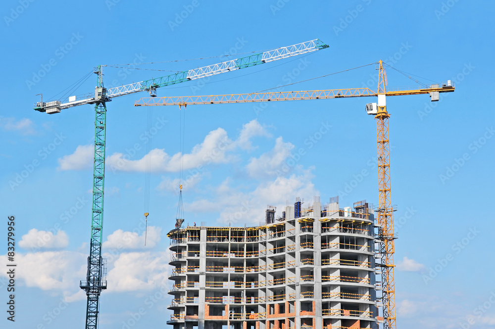 Crane and building construction site against blue sky