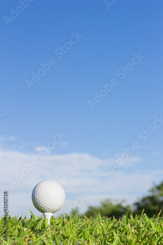 Golf ball on a tee with sky background