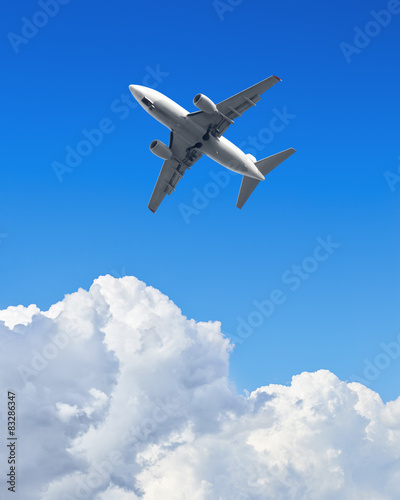 Airplane flying in the blue sky with clouds