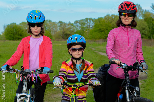 Mother and kids on bikes cycling outdoors, family sport 