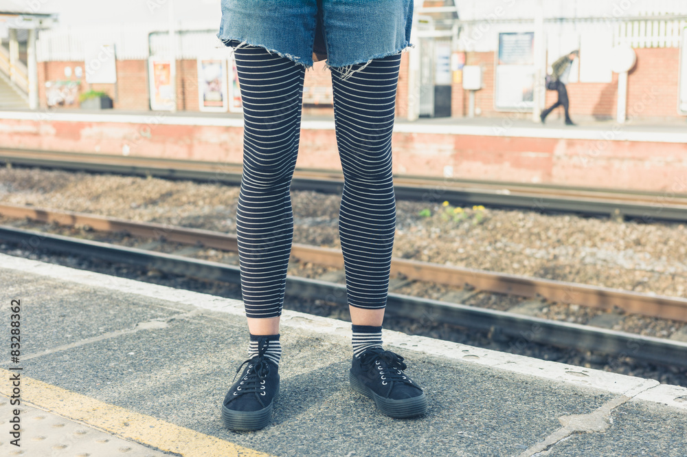 Young woman standing by railroad tracks Young woman standing by railroad tracks