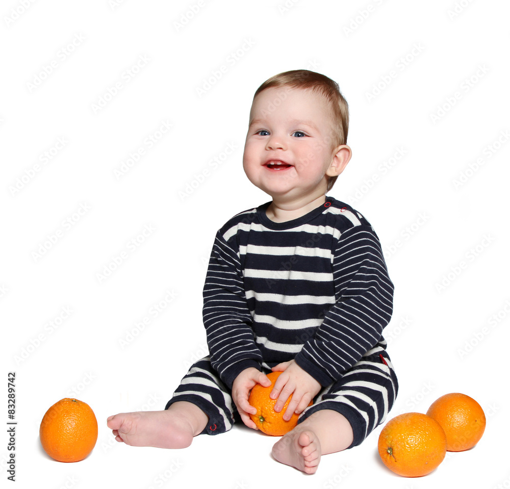 beautiful smiling baby sits with orange in hands beautiful smiling baby sits with orange in hands