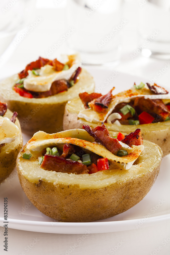 Baked potatoes stuffed with bacon, served with camembert