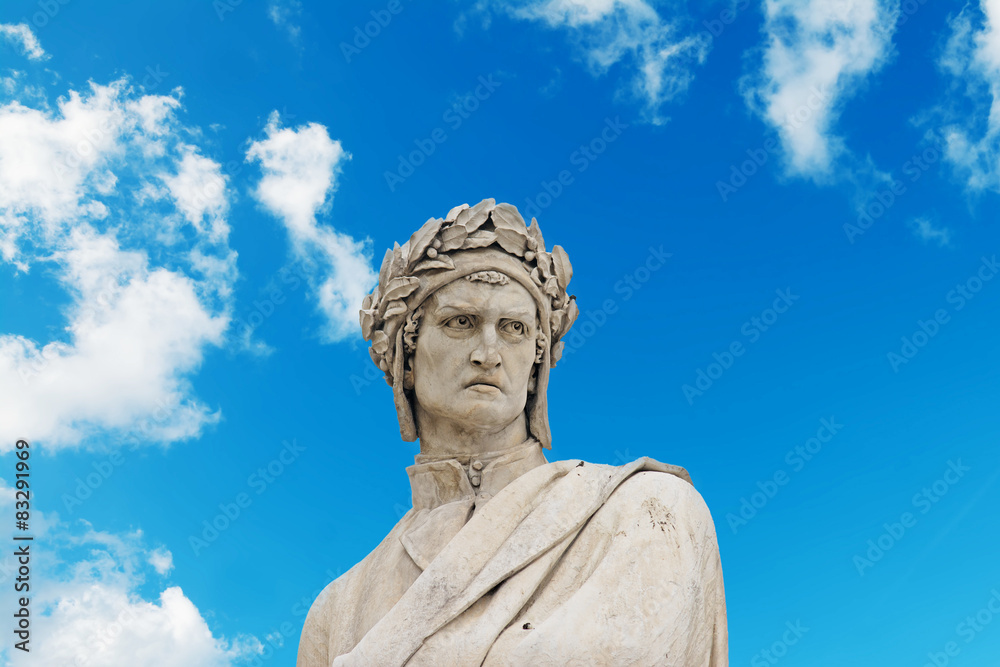 alighieri statue under a blue sky with clouds