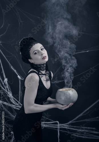 Halloween. Молодая ведьма с волшебным напитком