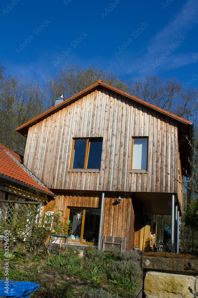 Idyllisches Holzhaus als Anbau eines Wohnhauses 