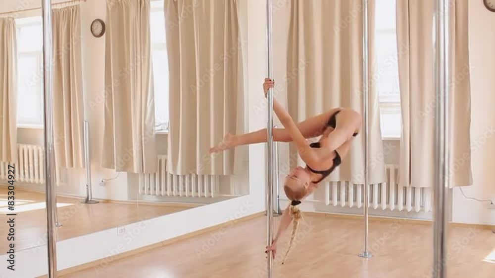 Young slim pole dance woman holding a pose