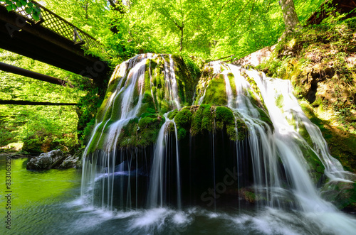 Bridge over the waterfall in the forest photo