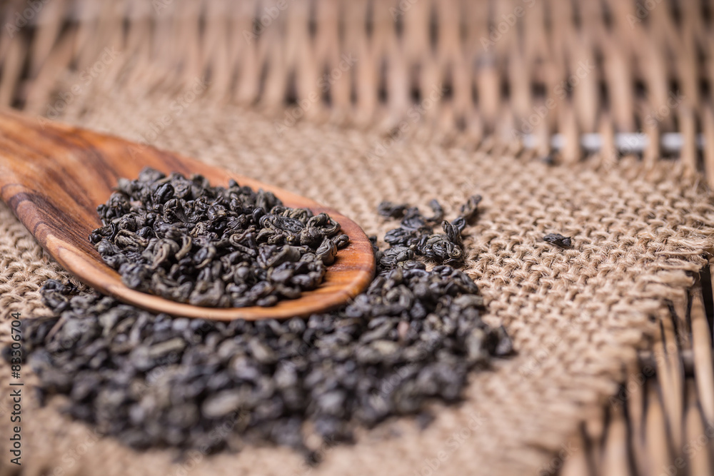 Dry tea in wooden spoon