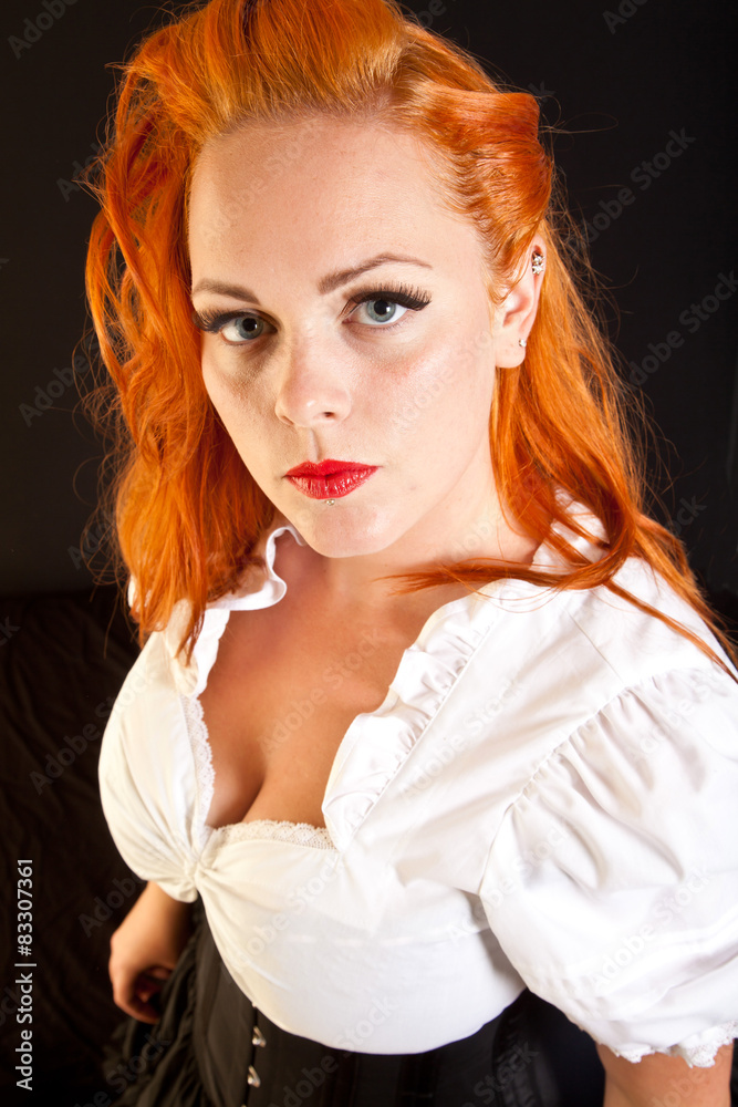 Fototapeta premium Red hair girl in pin-up style portrait shot in studio
