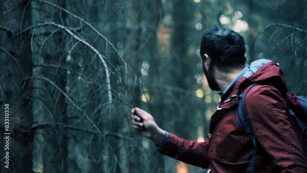 Young, frightened man running through the forest
