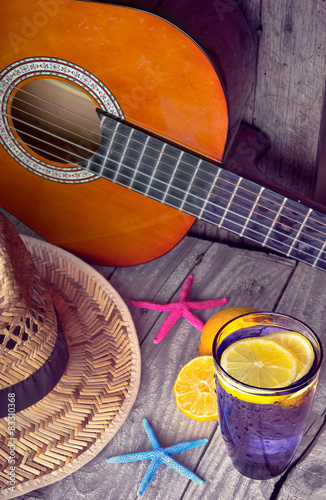 Acoustic guitar hat starfish and glass of tasty fresh lemonade photo