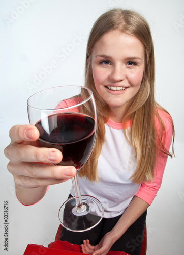 Scandinavian cute young girl holding a glass of wine in the air