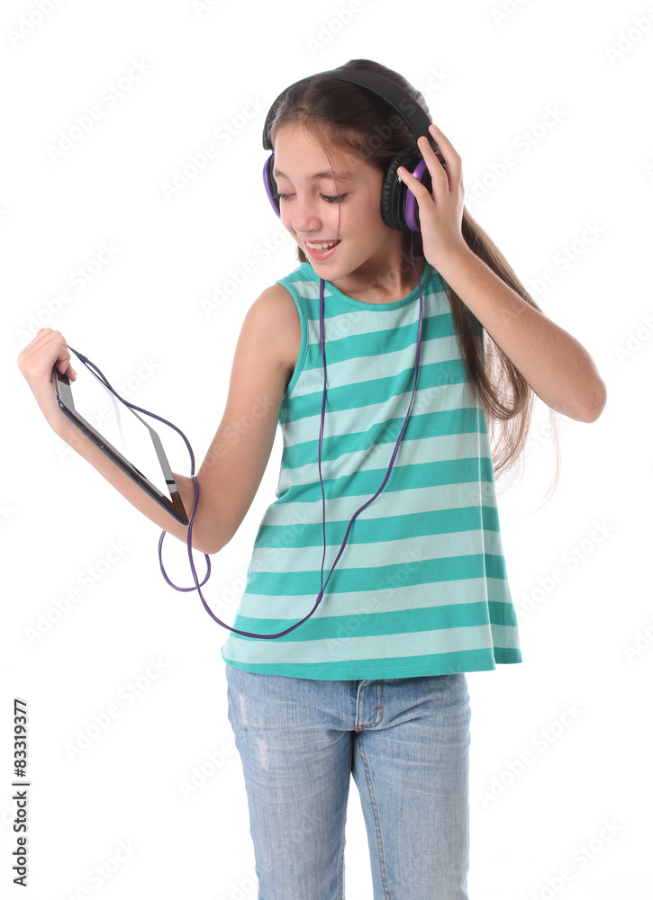 Beautiful pre-teen girl using a tablet computer and headphones. Beautiful pre-teen girl using a tablet computer and headphones.