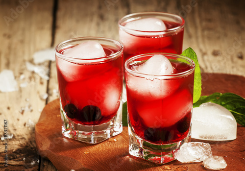 Red berry cocktail with mint and ice, selective focus