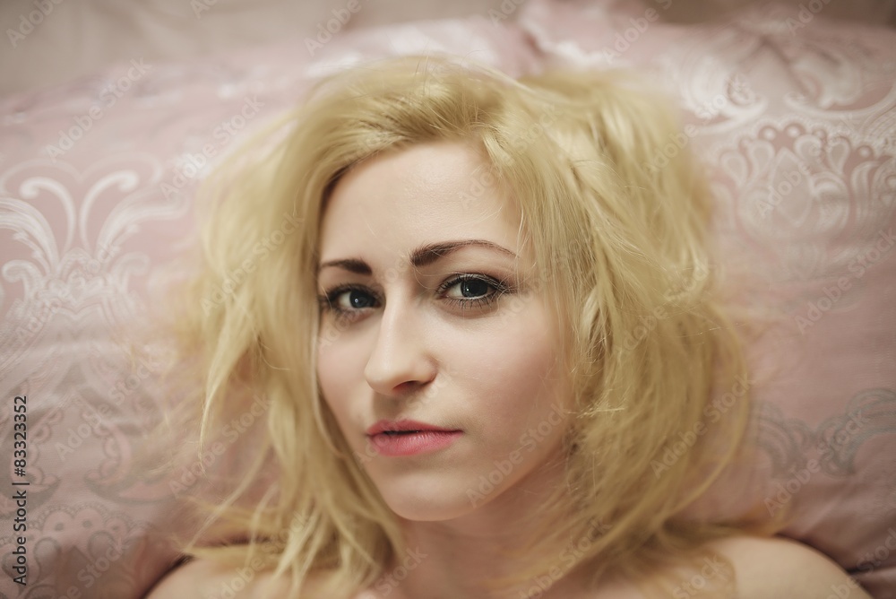 Young beautiful girl wakes up in the morning in a bed Young beautiful girl wakes up in the morning in a bed