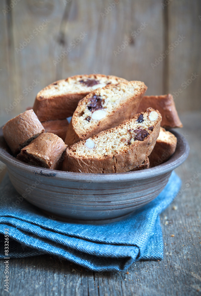 Homemade biscotti with chocolate and almonds in an old clay bowl