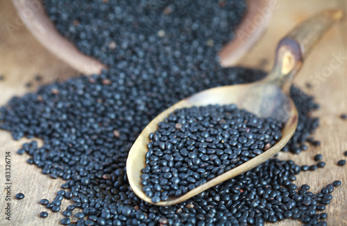 Dry black lentil beluga in a clay bowl and in a scoop 
